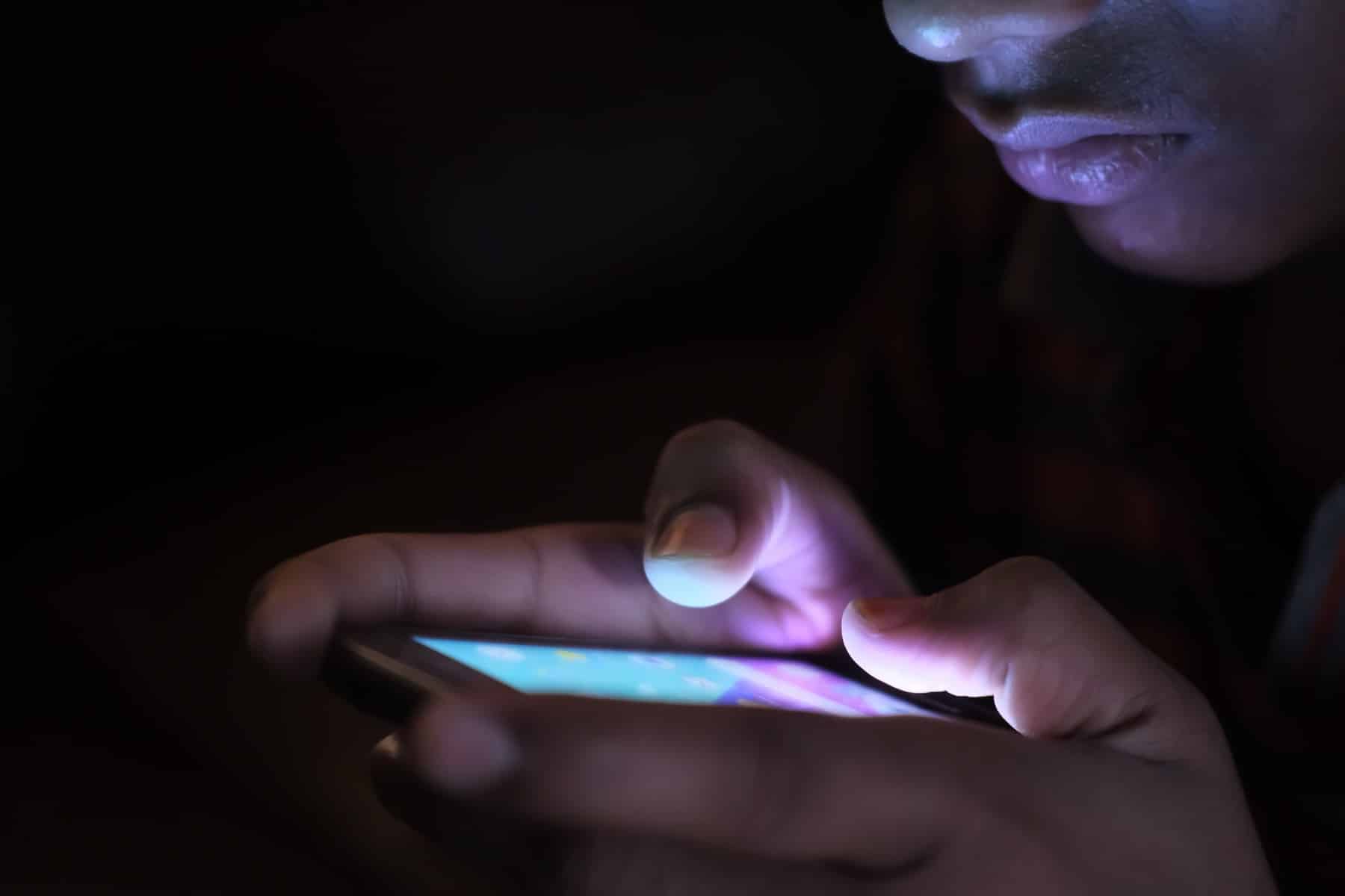 A person using a smartphone, illustrating the Facebook vs website choice for cleaners