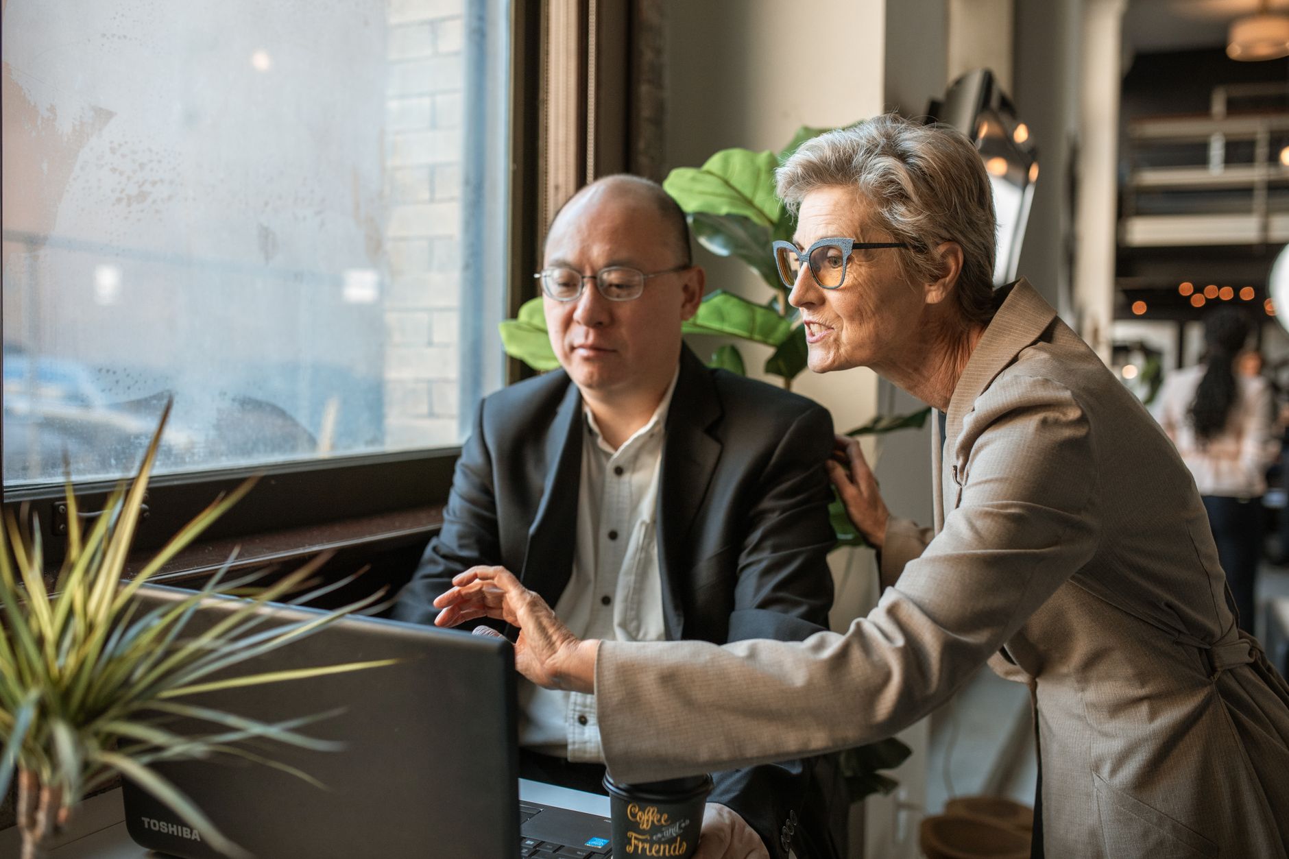 Cleaning business owner discussing plans with a cleaning website designer at a laptop