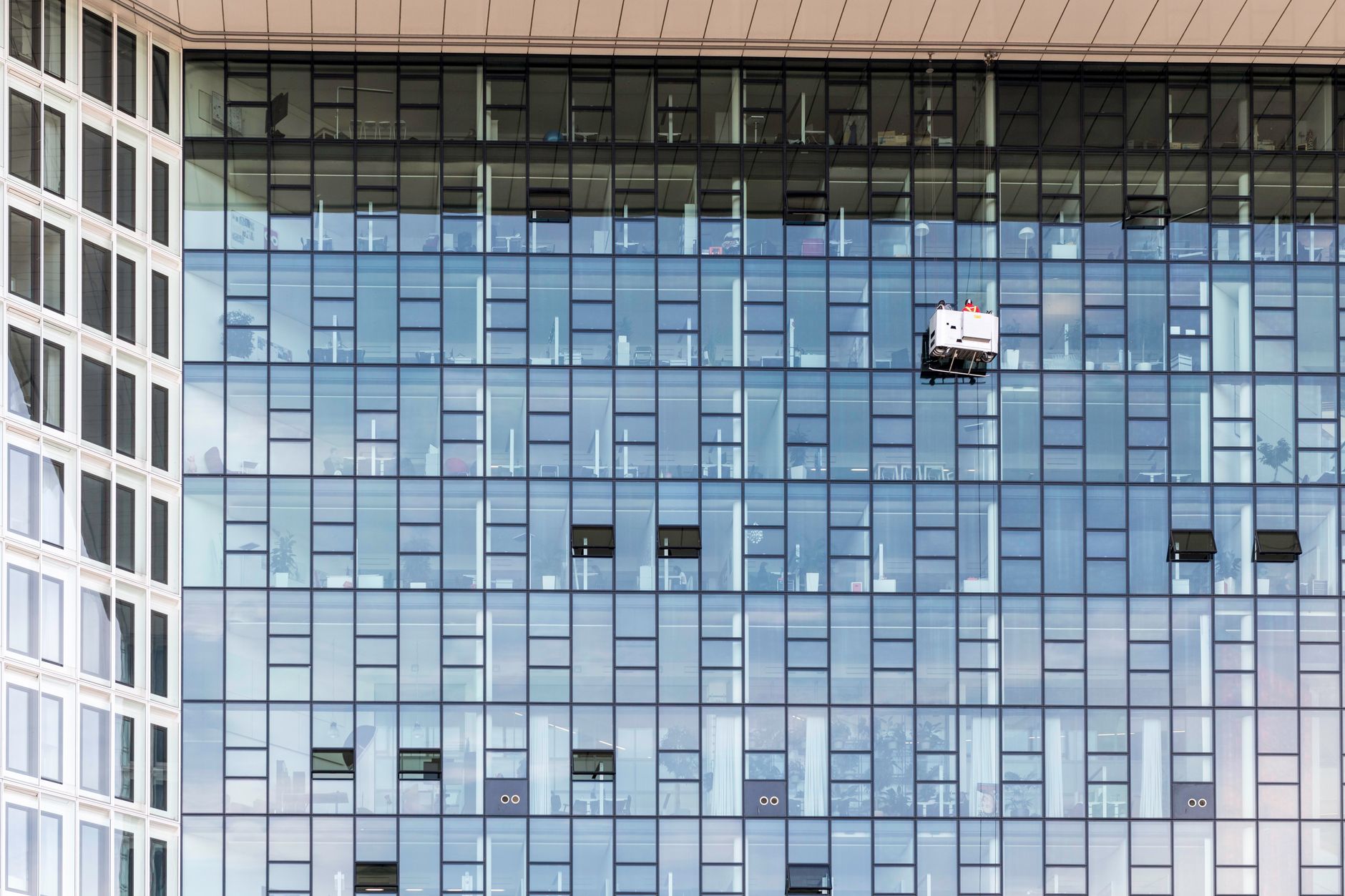 Cleaner working in a modern open plan office, illustrating office cleaning marketing to local businesses